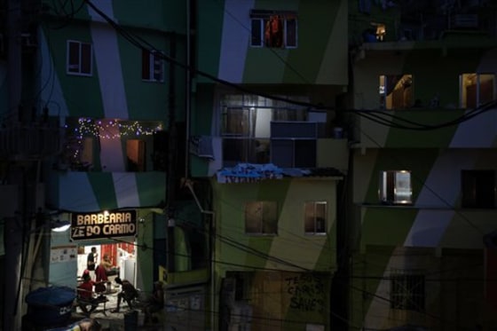 Customers get a haircut at the Ze do Carmo barbershop at the Santa Marta slum in Rio de Janeiro, Brazil, on Tuesday. The barber used to cut the hair of the neighborhood's drug dealers and of the addicts, but now tourists come in.